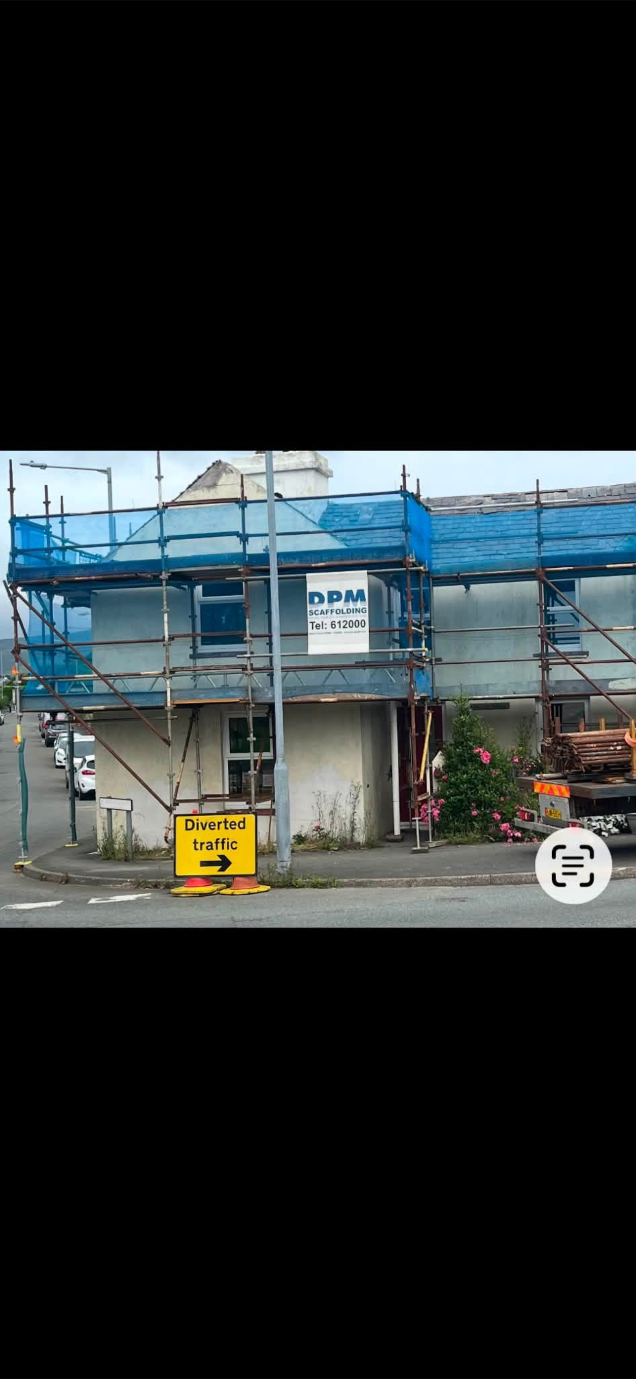 Blue-netted scaffolding around a roadside property